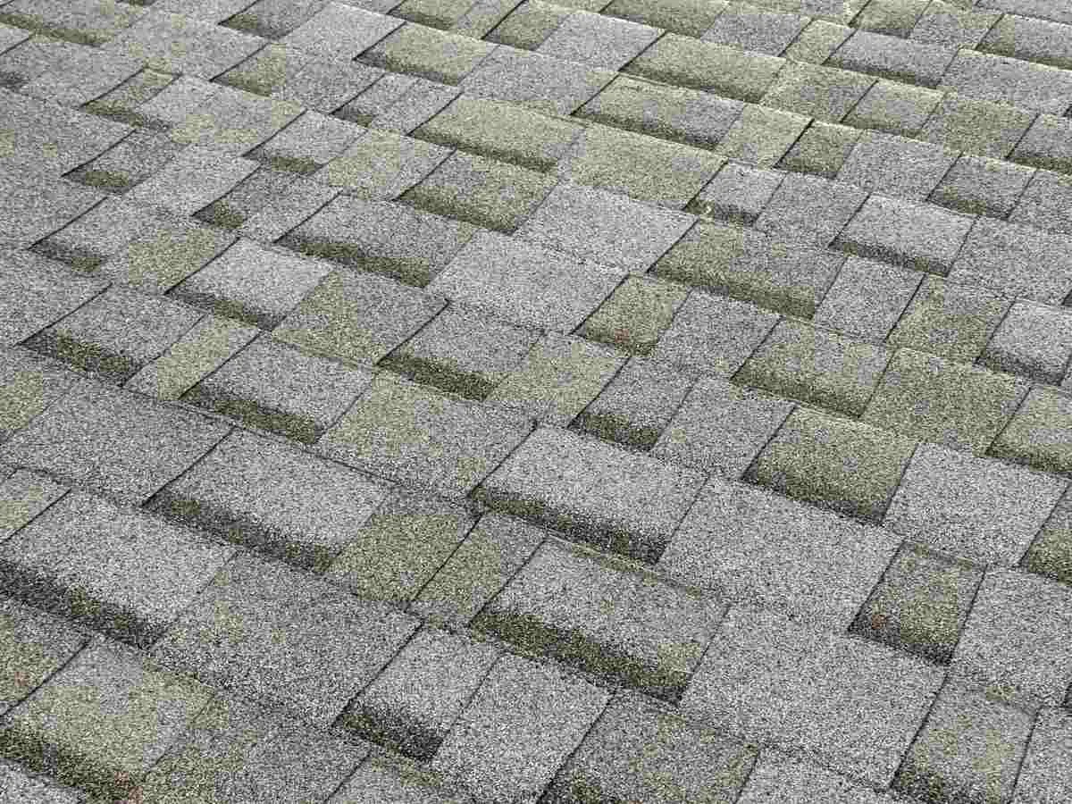 Close view of gray architectural asphalt shingles with granule texture in staggered courses